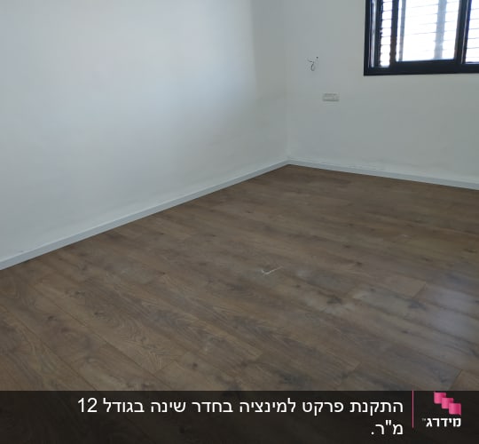 רצפת פרקט עץ כהה בחדר ריק עם קיר לבן